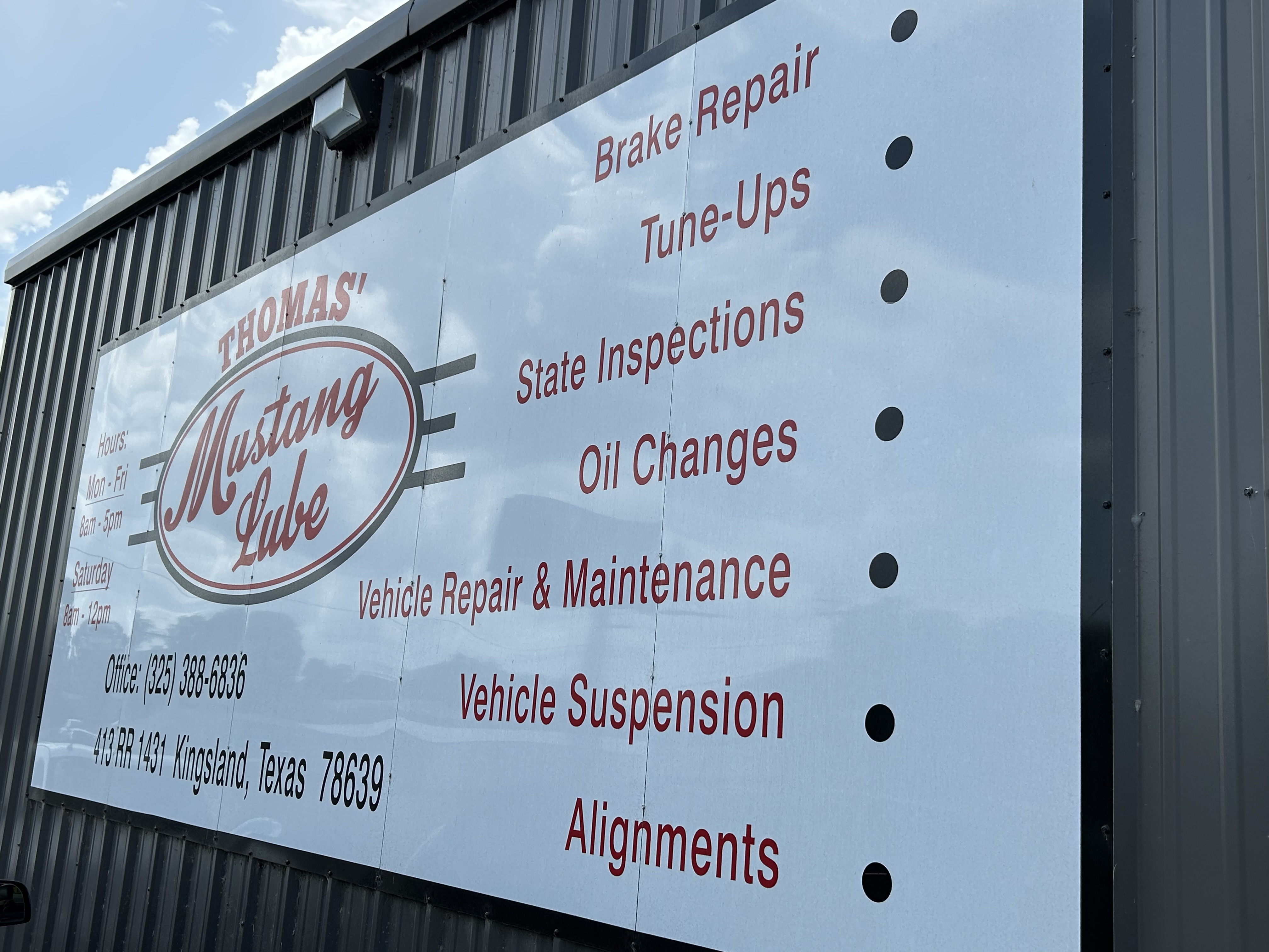 Thomas' Mustang Lube & Auto Repair shop sign listing services, hours, and address at 413 RR Hwy 1431, West Dr, Kingsland, TX